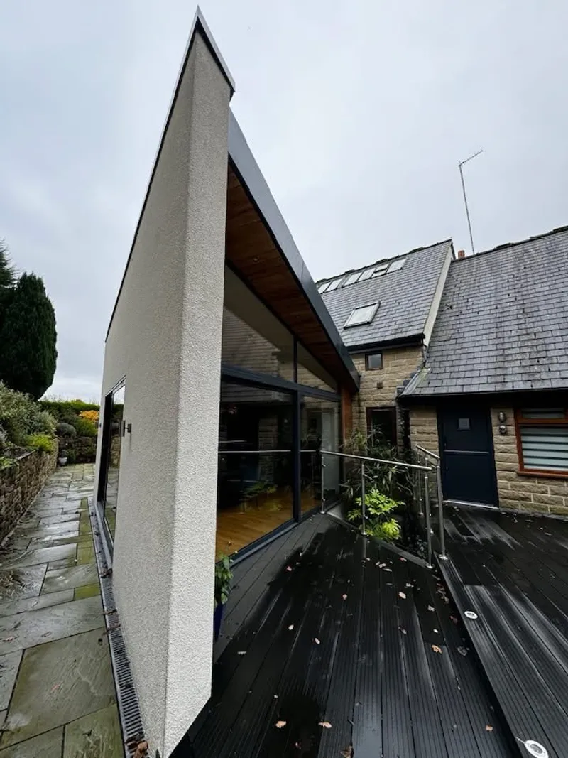 Rendered gable-end extension with full-height glazing and glass-balustrade deck